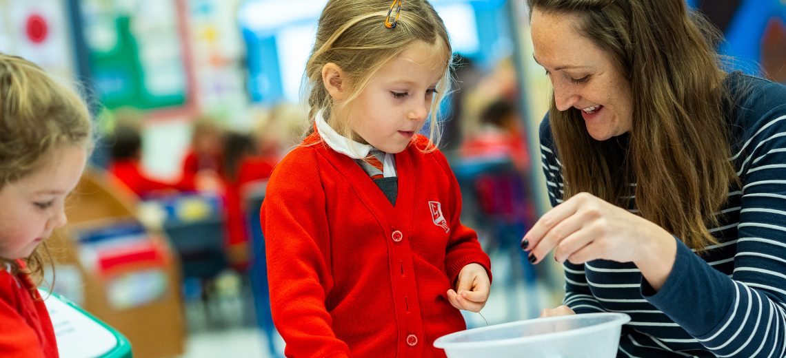 child counting buttons with teacher