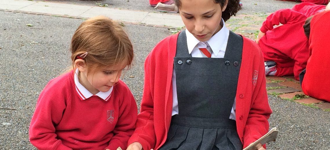 Older girl reading to younger girl